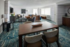 a hotel room with a table and a living room at Boston Marriott Peabody in Peabody