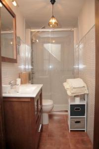 uma casa de banho com um chuveiro, um WC e um lavatório. em APARTAMENTO RURAL ABUELO EMILIO em Tornavacas