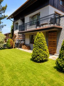 a house with a green lawn in front of it at GóralSki in Wisła