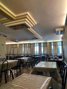 a dining room with tables and chairs and windows at Hotel Marea con Piscina NUOVA GESTIONE in Cattolica