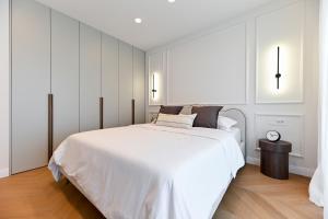 a white bedroom with a large white bed with black pillows at Casa Magista in Sukošan +70 photos