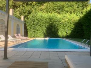 a swimming pool in a yard with two lounge chairs at Camere con piscina Tenuta BRICCHETTO in Castagneto Po
