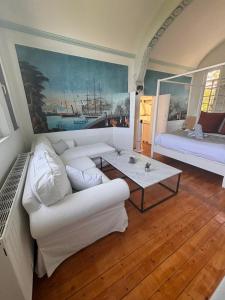 a living room with a white couch and a table at La maison de Blandine in Honfleur +36 photos