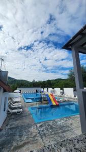 a group of three swimming pools with lounge chairs at Happy Time in Sredneye Vodyanoye