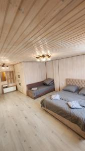 two beds in a room with a wooden ceiling at Happy Time in Sredneye Vodyanoye