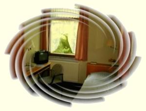 reflejo de una habitación en un espejo circular en Hotel Luginsland, en Schleiz