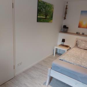 a small bedroom with a bed and a table at Das Zimmer - Bauernhof-Nordsee-Urlaub in Norderfriedrichskoog +2 photos