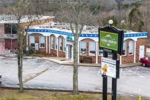 a sign in front of a building with a parking lot at Colonial Mountain Inn Branson MO in Branson West