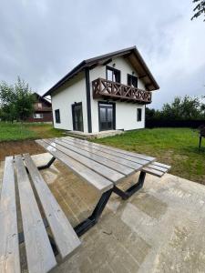 a large wooden picnic table in front of a house at Grey House in Vorokhta +7 photos