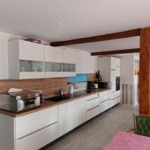 a kitchen with white cabinets and a counter top at Das Zimmer - Bauernhof-Nordsee-Urlaub in Norderfriedrichskoog