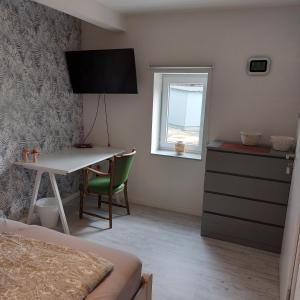 a bedroom with a desk and a bed and a window at Das Zimmer - Bauernhof-Nordsee-Urlaub in Norderfriedrichskoog