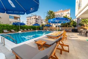 a swimming pool with tables and chairs and umbrellas at La Brisa Hotel in Antalya