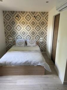 a bedroom with a bed with a wall at L'erable in Montlay-en-Auxois