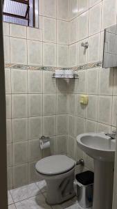 a bathroom with a toilet and a sink at Central APE Diamantina in Diamantina +3 photos