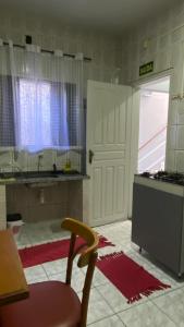 a kitchen with a door and a table and a chair at Central APE Diamantina in Diamantina