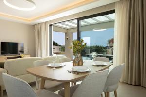 a dining room with a table and chairs and a large window at TATOLI Villas in Minia