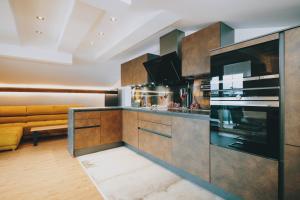 a kitchen with wooden cabinets and a couch at Mooslodge in Kaprun