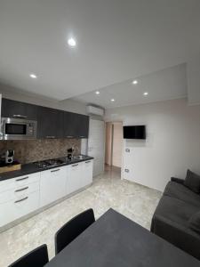 a kitchen with a couch and a table in a room at Tropea Olympus Apartments in Santa Domenica