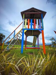 a colorful lifeguard chair sitting in the grass at Toca do Caranguejo-Iate Clube Rio Verde - Ilha Comprida in Cananéia