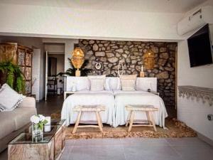 a bedroom with a large bed with a stone wall at Luxury Villa Private Pool in Mahajanga
