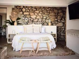 a bedroom with a large bed with a stone wall at Luxury Villa Private Pool in Mahajanga