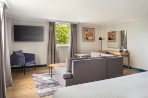 a living room with a couch and a chair at Edinburgh Marriott Hotel Holyrood in Edinburgh