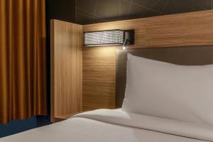 a bedroom with a white bed with a wooden headboard at SpringHill Suites by Marriott Norfolk Virginia Beach in Virginia Beach