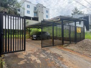 a black gate with a car parked under it at Hermosos Apartaestudios! in Florencia