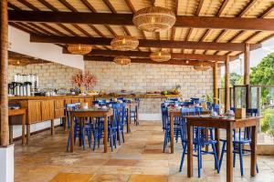 a restaurant with wooden tables and blue chairs at Vila Gallina Pousada in Jericoacoara