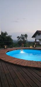 a large blue swimming pool with a wooden deck at Na Visu avlija in Kruševica