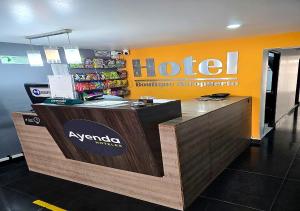 a hotel counter with a sign on the wall at Ayenda 1045 Boutique Aeropuerto in Bogotá
