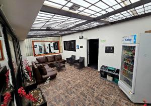 a living room with a leather couch and a tv at Ayenda 1045 Boutique Aeropuerto in Bogotá