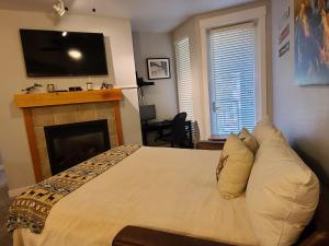 a bedroom with a bed with a fireplace and a television at Fraser Crossing 3417 in Winter Park