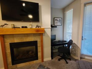 a living room with a fireplace with a television above it at Fraser Crossing 3417 in Winter Park