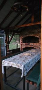 a table in a room with a brick oven at Na Visu avlija in Kruševica