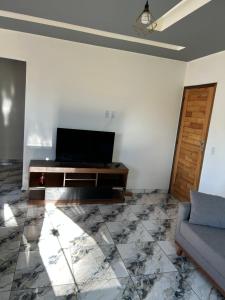 a living room with a television and a couch at Cataventooo hospedagens in Miguel Pereira