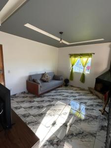 a living room with a couch and a television at Cataventooo hospedagens in Miguel Pereira +6 photos