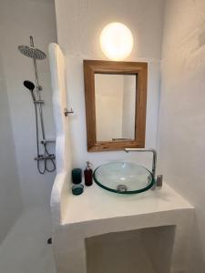 a bathroom with a glass sink and a mirror at 7olives Golden Boutique Apartment in Kastraki +26 photos