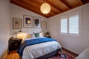 a bedroom with a bed with a blue comforter and a window at The Heights in St Helens