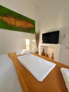 a room with a bed with a white sheets and a refrigerator at 7olives Golden Boutique Apartment in Kastraki