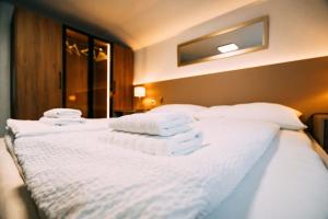 a bed with white towels stacked on top of it at Cozy Apartment - Stunning Views in Brienz +35 photos
