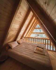 a bed in a loft with a large window at BetosGarden in Ulcinj