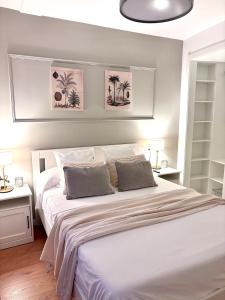 a bedroom with a large white bed with two pillows at Alojamiento D'Moda in Ribadeo
