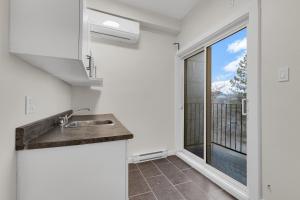 a kitchen with a sink and a large window at Maison Paris- Quartier des Spectacles in Montreal