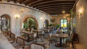a restaurant with tables and chairs in a room at Hotel Capellán de Getsemaní in Cartagena de Indias