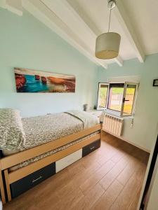 a bedroom with a bed and a painting on the wall at La Casita cerca de la playa in Santander