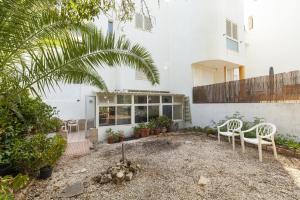 a patio with two white chairs and a building at Praia da Luz Coast Flat in Luz