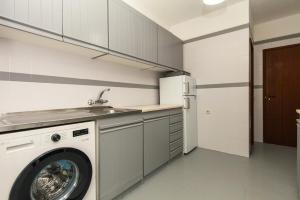 a kitchen with a washing machine and a sink at Praia da Luz Coast Flat in Luz