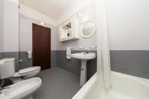a bathroom with a white toilet and a sink at Praia da Luz Coast Flat in Luz +13 photos