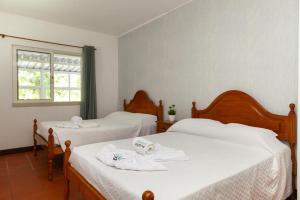 a bedroom with two beds with towels on them at Praia da Luz Coast Flat in Luz